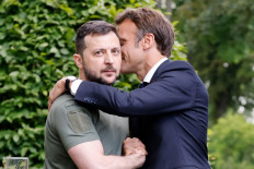 Ukrainian President Volodymyr Zelensky (left) and French Fresident Emmanuel Macron embrace after giving a press conference in at Mariinsky Palace in Kyiv, on June 16, 2022. The leaders of major EU powers France, Germany and Italy vowed on June 16 to help Ukraine defeat Russia and to rebuild its shattered cities, in a visit to a war-torn Kyiv suburb.