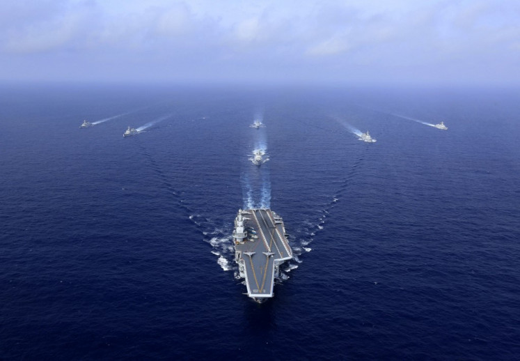 This photo taken on April 18, 2018 shows China's sole operational aircraft carrier, the Liaoning (center), sailing during a drill at sea. 