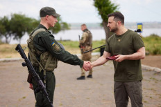 This handout picture taken and released by the press service of the Ukrainian Presidency on 18 June, 2022 shows Ukrainian President Volodymyr Zelensky (right) awarding a serviceman during his visit to the position of Ukrainian National Guard in Odessa region. 