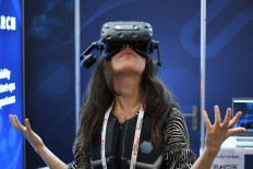 A staff member of the start-up Actronika shows the use of a virtual vest and headset during the Vivatech startups and innovation event in Paris on June 16, 2022.