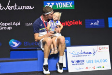 Denmark’s Viktor Axelsen holds his daughter during the victory ceremony after winning the men’s singles event at the Indonesia Open badminton tournament in Jakarta on June 19, 2022. 