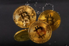 Souvenir tokens representing cryptocurrency bitcoin plunge into water in this illustration taken May 17, 2022