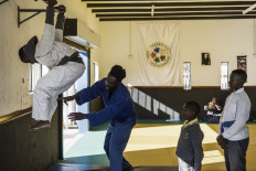 Level up: Congolese coach Rudolph Ngala, of the Dojo for Hope in Alexandra, Johannesburg, South Africa, helps one of his young students to perform an exercise on June 6.