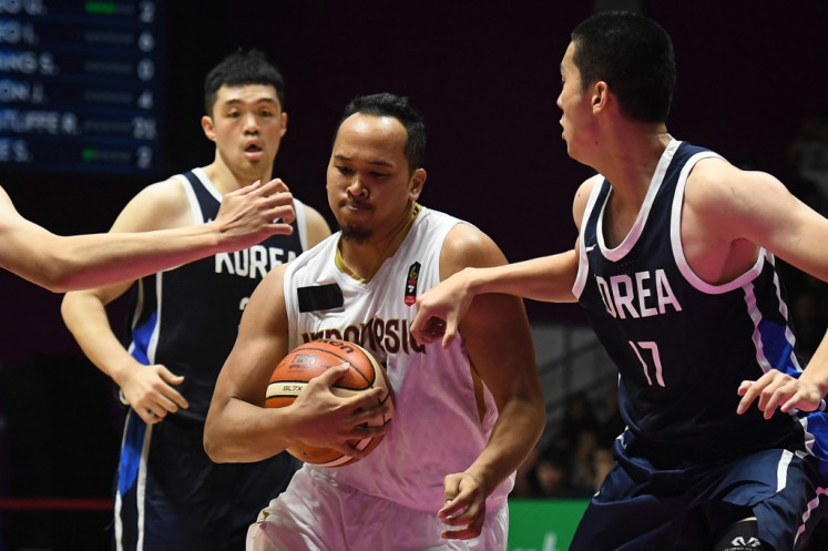 In action: Indonesia's Arki Dikania Wisnu (center) protects the ball past South Korean players during the men's basketball preliminary Group A game between Indonesia and South Korea during the 2018 Asian Games in Jakarta on August 14, 2018. 