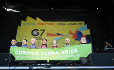 Protesters wearing masks of (left-right) French President Emmanuel Macron, Japanese Prime Minister Fumio Kishida, US President Joe Biden, Canadian Prime Minister Justin Trudeau, German Chancellor Olaf Scholz, British Prime Minister Boris Johnson and Italian Prime Minister Mario Draghi stand on a stage as they take part in a demonstration called for by Greenpeace, Attac and other organisations ahead of the G7 Summit at the Theresienwiese in Munich, southern Germany on June 25, 2022. 