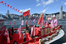 A fishing boat with banners and flags to mark the 25th anniversary of the Handover of Hong Kong from Britain to China is moored in Hong Kong’s Victoria harbour on June 28, 2022. The Handover anniversary falls on July 1.
