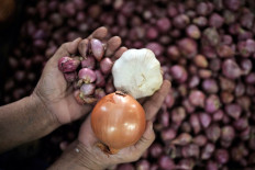 A trader shows onions, shallots and garlic on June 27, 2022 at Mandonga Market in Kendari, Southeast Sulawesi.
