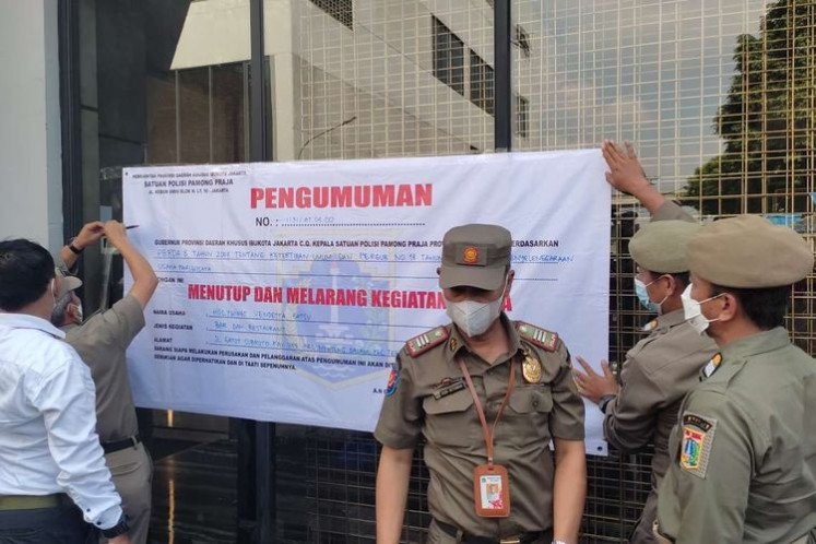 The Jakarta Public Order Agency (Satpol PP) seals the Holywings Vendetta outlet in Gatot Subroto, Jakarta, on Tuesday. (Kompas.com/Singgih Wiryono)