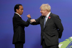 Britain's Prime Minister Boris Johnson greets Indonesia's President Joko Widodo as they arrive to attend the COP26 UN Climate Change Conference in Glasgow, Scotland on November 1, 2021. COP26, running from October 31 to November 12 in Glasgow will be the biggest climate conference since the 2015 Paris summit and is seen as crucial in setting worldwide emission targets to slow global warming, as well as firming up other key commitments.