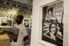Photographer Dennis Morris gestures during an interview with the AFP at his exhibition 