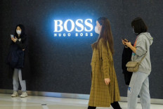 Back on track: People walk past a store of German fashion house Hugo Boss in Beijing, China, on March 27, 2021. After five years with the electric Formula E series, Hugo Boss will return to Formula One with the Aston Martin team, the brand announced on Thursday.