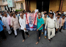 Two sons of Kanhaiyalal Teli, a Hindu tailor, who was killed by two suspected Muslims after they videoed themselves slaying him, carry a portrait of their father after a prayer meeting in Udaipur in the northwestern state of Rajasthan, India, June 30, 2022