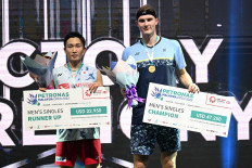 Denmark’s Viktor Axelsen (right) poses with his gold medal next to silver medallist Japan's Kento Momota (left) after the men's singles final at the Malaysia Open badminton tournament in Kuala Lumpur on July 3, 2022. 
