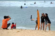 Life’s a beach: Tourists pose for photographs on Kuta Beach in Bali on Jan. 4, 2019. The government is offering so-called “digital nomad” visas to foreigners in a bid to boost post-pandemic tourism.