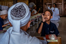 This picture taken on June 22, 2022 shows a student reciting the Koran using sign language at an Islamic boarding school for deaf children in Sleman. At an Islamic boarding school in a sleepy neighbourhood on the outskirts of Indonesian city Yogyakarta, the evocative sound of Koranic recitation is nowhere to be heard.