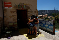 Alberto Toro, his current students and two former students of his who came to say good-bye, blend into a hug on the last day of school in the small Spanish village of Pitarque, Teruel, one of the least populated regions of the European Union, June 21, 2022. Two former students of his attended the last day of school together with the last four students to bid him farewell. 