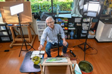 This picture taken on May 25, 2022 shows Japanese art instructor Harumichi Shibasaki painting with watercolours in his atelier in Isumi, Chiba prefecture. Harumichi Shibasaki was nearly 70 when he began making YouTube art tutorials from his quiet home in the Japanese countryside. Five years on, he has 1.4 million subscribers.
