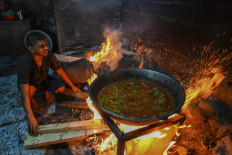 In this picture taken on March 15, 2022, a man uses firewood to cook food at a hotel in Colombo. As once relatively wealthy Sri Lanka suffers a dire economic crisis with shortages of everything from medicines to gas, locals are returning to cooking with firewood.
