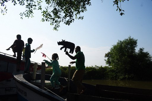 Learning together: Children learn about animal conservation from a teacher using cardboard puppets at Cemara Kulon village in Indramayu, West Java in this picture taken on Jun. 19.