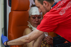 An injured woman is helped by an ambulance nurse after an air strike in the courtyard of hotel Industria and civilian residences in the center of Kramatorsk, on July 7, 2022. An air strike on July 7, 2022 killed at least one person and wounded several others in Kramatorsk, an administrative centre of Ukraine's eastern region under Russian attack, AFP journalists said. 
