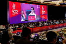 Foreign Minister Retno LP Marsudi (on screen) delivers a speech during the G20 Foreign Ministers' Meeting in Nusa Dua on the Indonesian resort island of Bali on July 8, 2022. 
