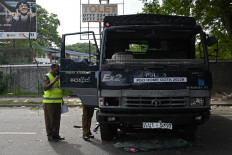 Members of security personnel inspect a police vehicle, a day after it was vandalised by the protestors in front of the residence of Sri Lanka's Prime Minister, in Colombo on July 10, 2022. Sri Lankan protesters set the prime minister's private home on fire, hours after chasing the president from his residence, as months of frustration over an unprecedented economic crisis boiled over on July 9.
