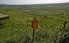 A sign warning against landmines is seen by a barbed-wire fence in the Israeli-annexed Golan Heights on April 22, 2021 near the border fence with the Syrian governorate of Quneitra.
