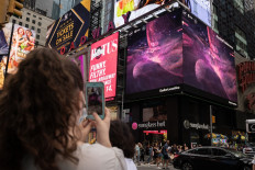 A person takes a video of the gians screens displaying images captured by The James Webb Space Telescope in Times Square on July 12, 2022 in New York. Released one by one starting from 10:30 am Eastern (1430 GMT) at the Goddard Space Flight Center, the new images demonstrated the full power of the $10 billion observatory, which uses infrared cameras to gaze into the distant universe with unprecedented clarity.
