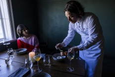 Double-Michelin-starred Faroese chef of KOKS restaurant Poul Andrias Ziska (R) serves Greenlandic halibut with horseradish and dill sauce in the restaurant housed in the Poul Egedes House in Ilimanaq, Greenland, on June 28, 2022. Restaurant Koks, usually housed in the Faroe Islands, where they have been awarded two Michelin stars, moved to Ilimanaq Lodge and is open between June 12 and September 8, 2022 and 2023, serving a tasting menu in the small settlement 300km north of the polar circle, home to 53 permanent residents.
