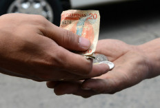 A street vendor gives Philippine peso currency change to a customer in Manila on September 13, 2012. 