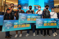 BNI president director Royke Tumilaar (third right), vice president director Adi Sulistyowati (right) and sales director Adiwinahyu Basuki Sigit (left) stand with the winners of the For Stronger Indonesia eSports tournament, Friday (7/15). Through the competition, BNI plays a proactive role in developing the gaming sector in Indonesia and nurturing game creators who can attract global attention.