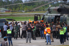 Police and military personnel transfer victim's bodies from a helicopter to an ambulance in Timika on July 16, 2022. The armed wing of the Free Papua Movement (OPM) has claimed responsibility for the attack that killed 11 unarmed civilians and injured one.