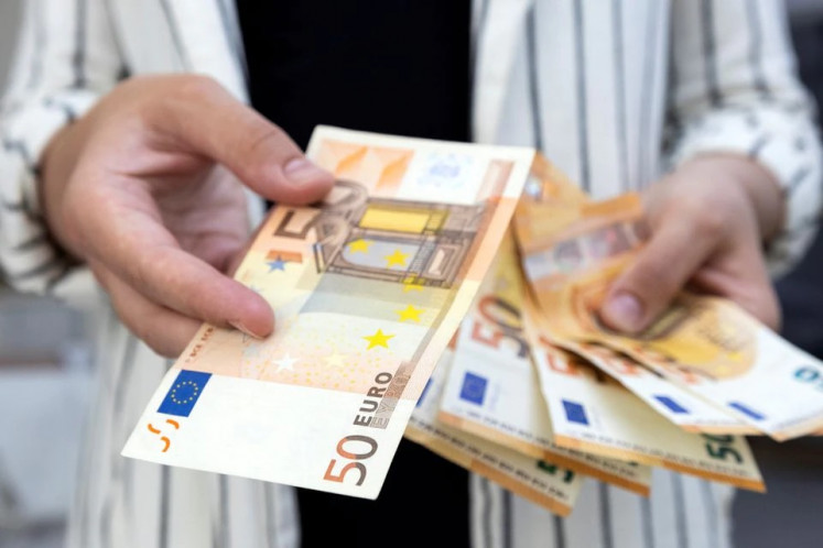 A woman holds euro banknotes in this illustration photo taken on May 30, 2022.