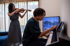Quality time: Shizuka Kimura (left) and her husband Kazuki play violin and piano in their house by the sea, where they moved to from a cramped Tokyo apartment amid a not insignificant post-pandemic migration.
