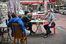 Men have beers on a street in Hong Kong, China, on March 29, 2022.