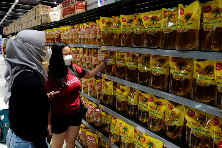 People shop for cooking oil on March 27, 2022, at a supermarket in Jakarta.