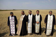 Rain prayers: Priests attend a religious service performed for rain to end the drought near Draganesti-Vlasca, Teleorman county, Romania, on July 4.  