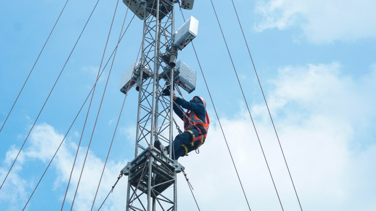 A worker installs Ericsson telecommunication equipment for 5G cellular services for the Jakarta ePrix championship held in Central Jakarta in June 2022.