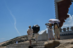 Smoke trails from projectiles launched by the Chinese military are seen in the sky as tourists look on from Pingtan Island, one of mainland China's closest points to Taiwan, in Fujian province on Aug. 4.