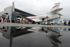 Leaving on a private jet plane: People gather next to private business jets parked on the tarmac of an airstrip during the Aerospace exhibition in Hong Kong on March 8, 2011. 