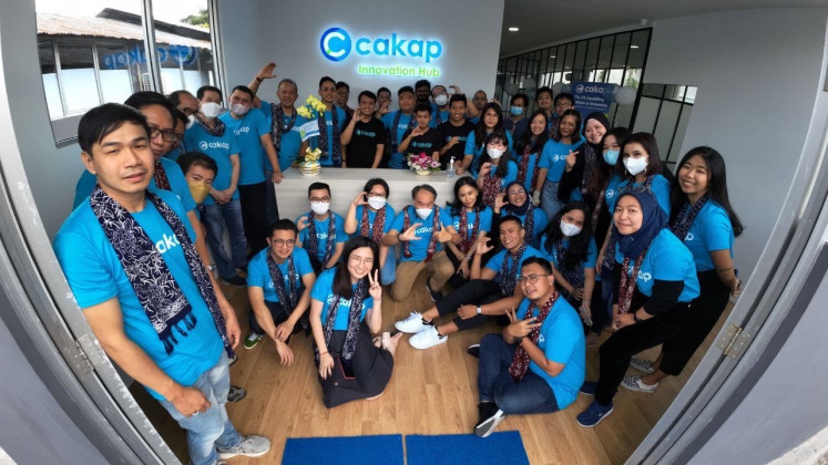 Cakap employee (Cakap Squad) poses in front of the Innovation Hub’s Lobby.