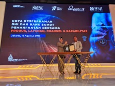 BNI vice president director Adi Sulistyowati (left) and North Sumatran Bank (Bank Sumut) president director Rahmat Fadilah Pohan clasp hands after signing a memorandum of understanding on the Orange Synergy program at BNI Tower in Jakarta. Through Orange Synergy, Bank Sumut will be able to diversify its banking products and services. BNI can also expand services related to taxpaying and regional retribution in North Sumatra through ATM channels, mobile banking, agencies and BNI outlets.