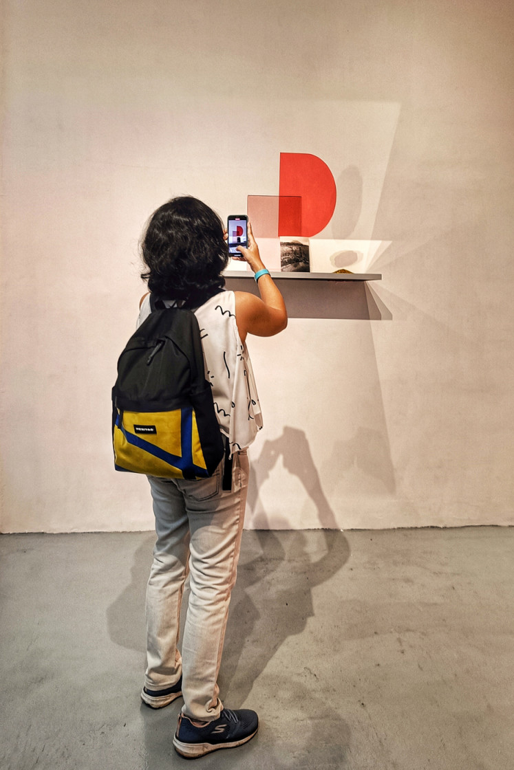 Admiring art: A visitor takes a picture of the mirror shelf at the exhibition, which is being held at the ISA Art Gallery in Wisma 46 in Central Jakarta. (JP/Sylviana Hamdani)
