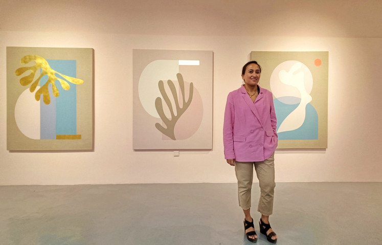 Meet the artist: Sinta Tantra poses in front of a series of paintings dedicated to her maternal family during the opening of the Constellation of Beings exhibition on Aug. 5. (JP/Sylviana Hamdani)