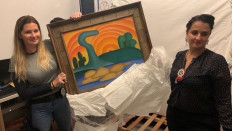 Familial fraud: A civil investigator and a delegate from the Brazilian police display artist Tarsila do Amaral's painting, Sol Poente, after it was seized during a police operation on Wednesday in Rio de Janeiro.