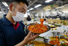 This photo taken on June 17, 2022 shows factory head Hiroaki Miyazawa checking a finished plastic food sample at an Iwasaki Group factory in Yokohama, Kanagawa prefecture. From the 