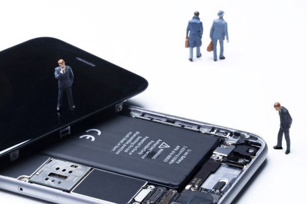 Figurines stand around an opened smartphone in a photo studio in Paris on July 23, 2021.