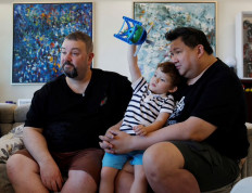 Not that progressive: Same-sex-parents Andre Ling, 44, and Cameron Sutherland, 47, play with their two-year-old son Tyler at home, as they share their views on the repeal of a law criminalizing sex between men, known as Section 377A, in Singapore, on Monday