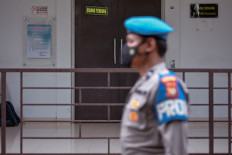 A police officer stands guard outside a courtroom during the trial of Islamist leader Zulkarnaen, accused of organising the Bali bombings in 2002, at a district court in Jakarta on January 19, 2022. 
