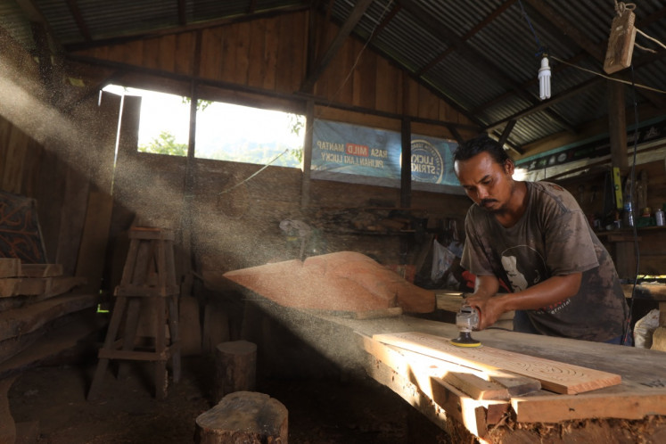 Spiritual calling: Jesral Tambun works in his workshop in Toba regency, North Sumatra. The workshop is in his house, which he restored after a fire burned it down and propelled him on his spiritual journey in pursuit of ethnic art. (Courtesy of Jesral Tambun)